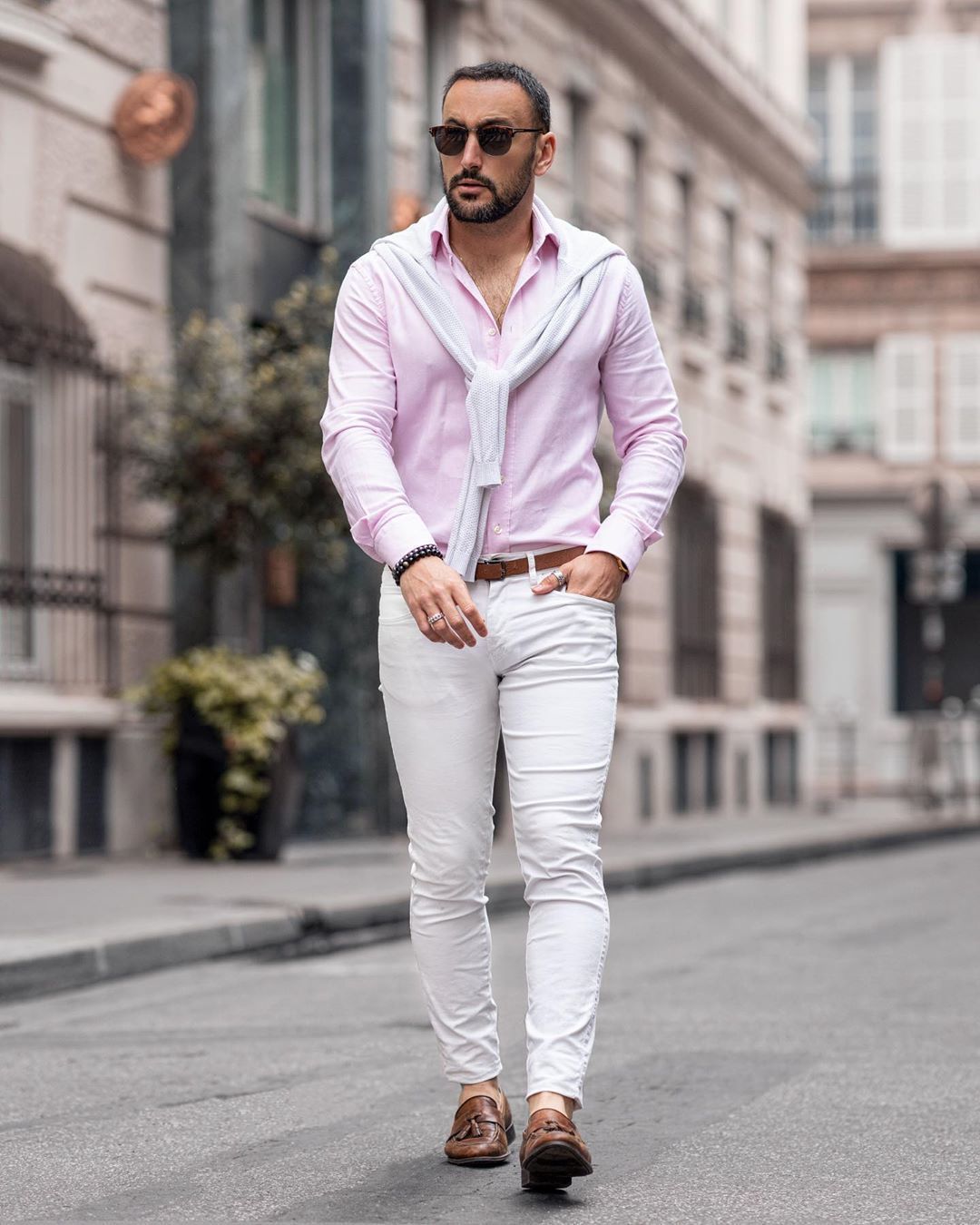 White crew-neck sweater, pink long-sleeve shirt, white chinos, and brown loafers outfit