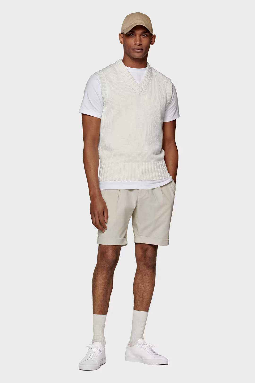 White sweater vest, white t-shirt, cream shorts and white sneakers outfit